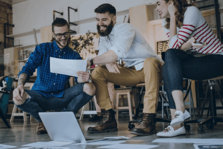 Three inventors reviewing documents while preparing a patent application